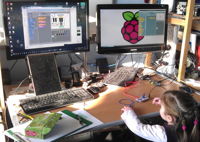 Young girl reaching to the computer